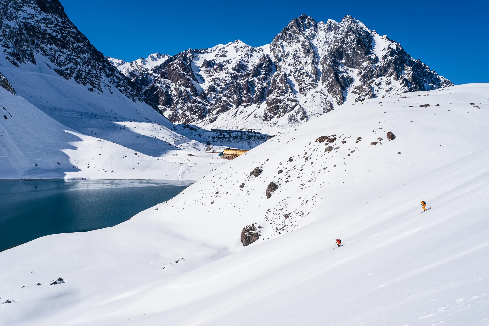 Skiers with entire lake panorama
